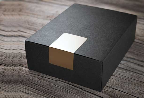 Rectangular gold sticker holding together black box packaging